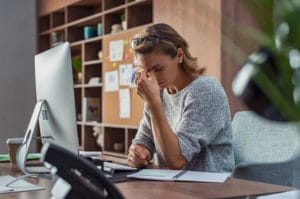 A woman experiencing headache due to work-related stress