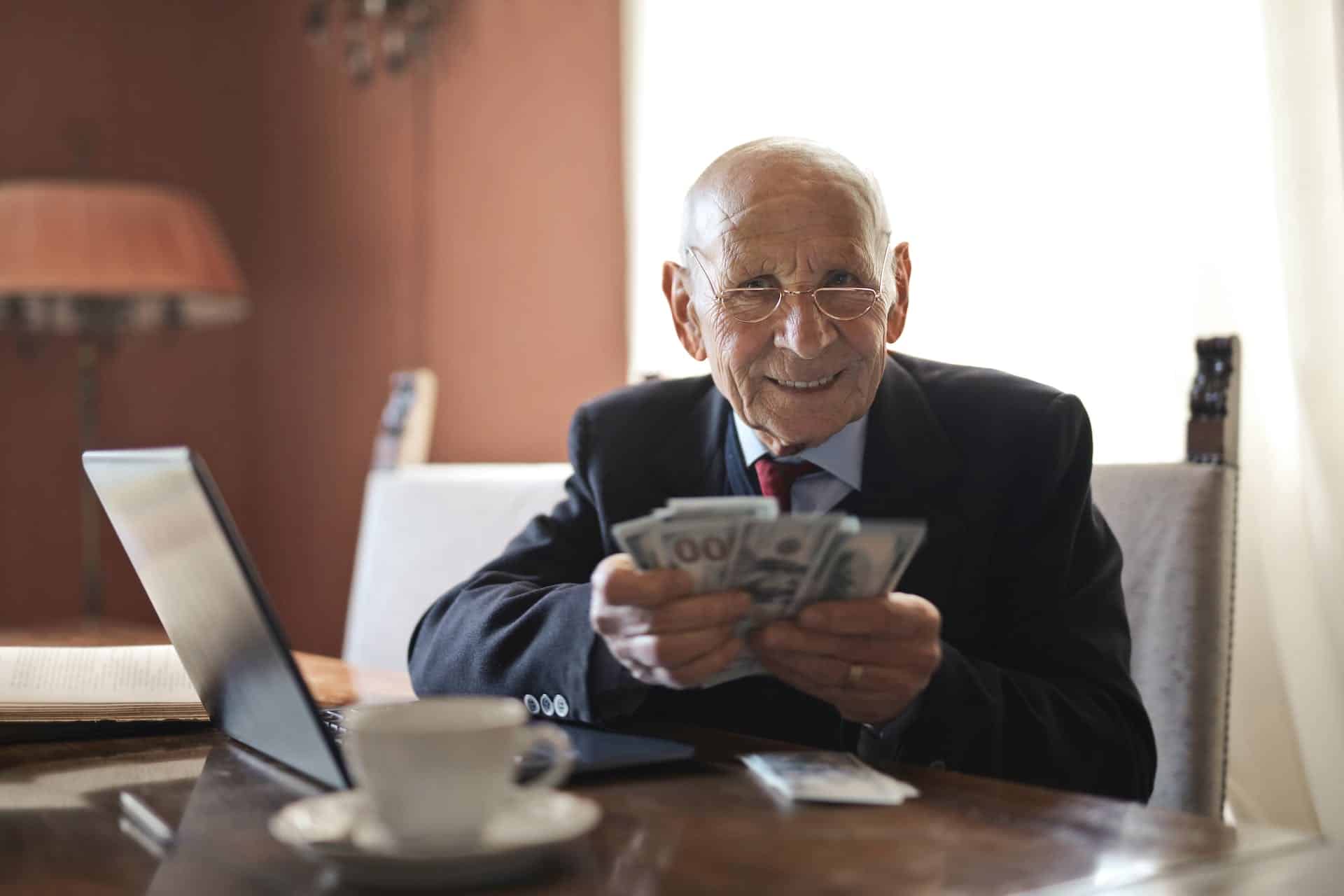 Old man holding dollar bills