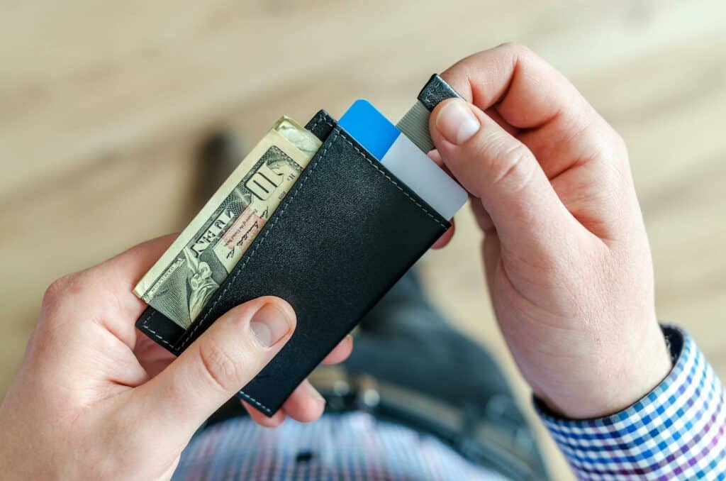 A person holding a black cardholder