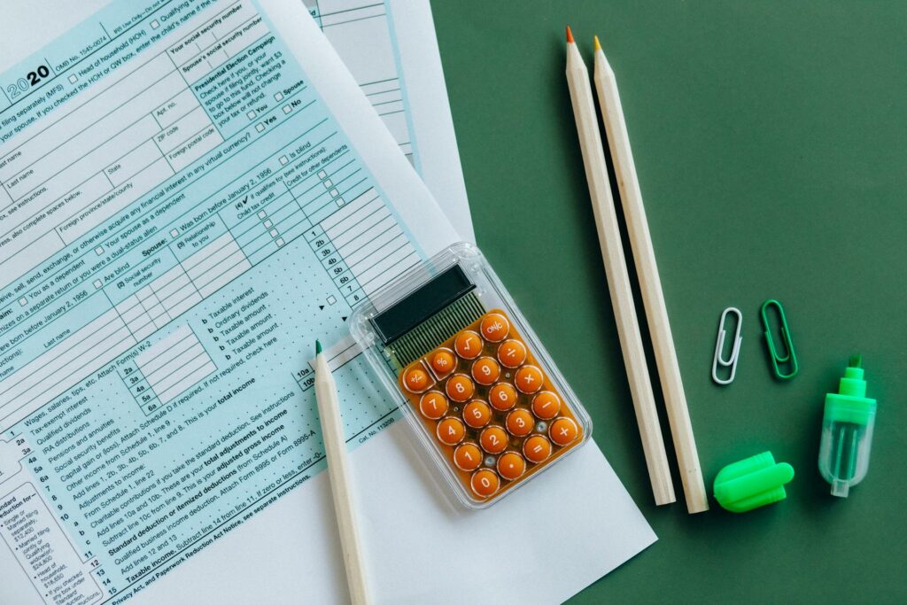 Tax documents, pens, and calculator on a table