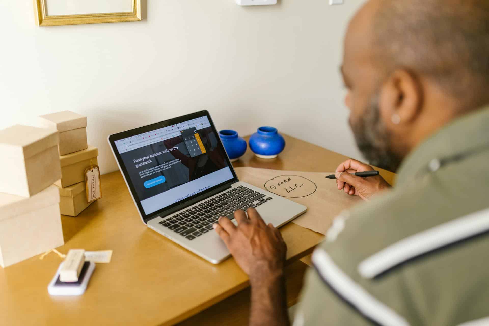 A man looking at a website on a laptop