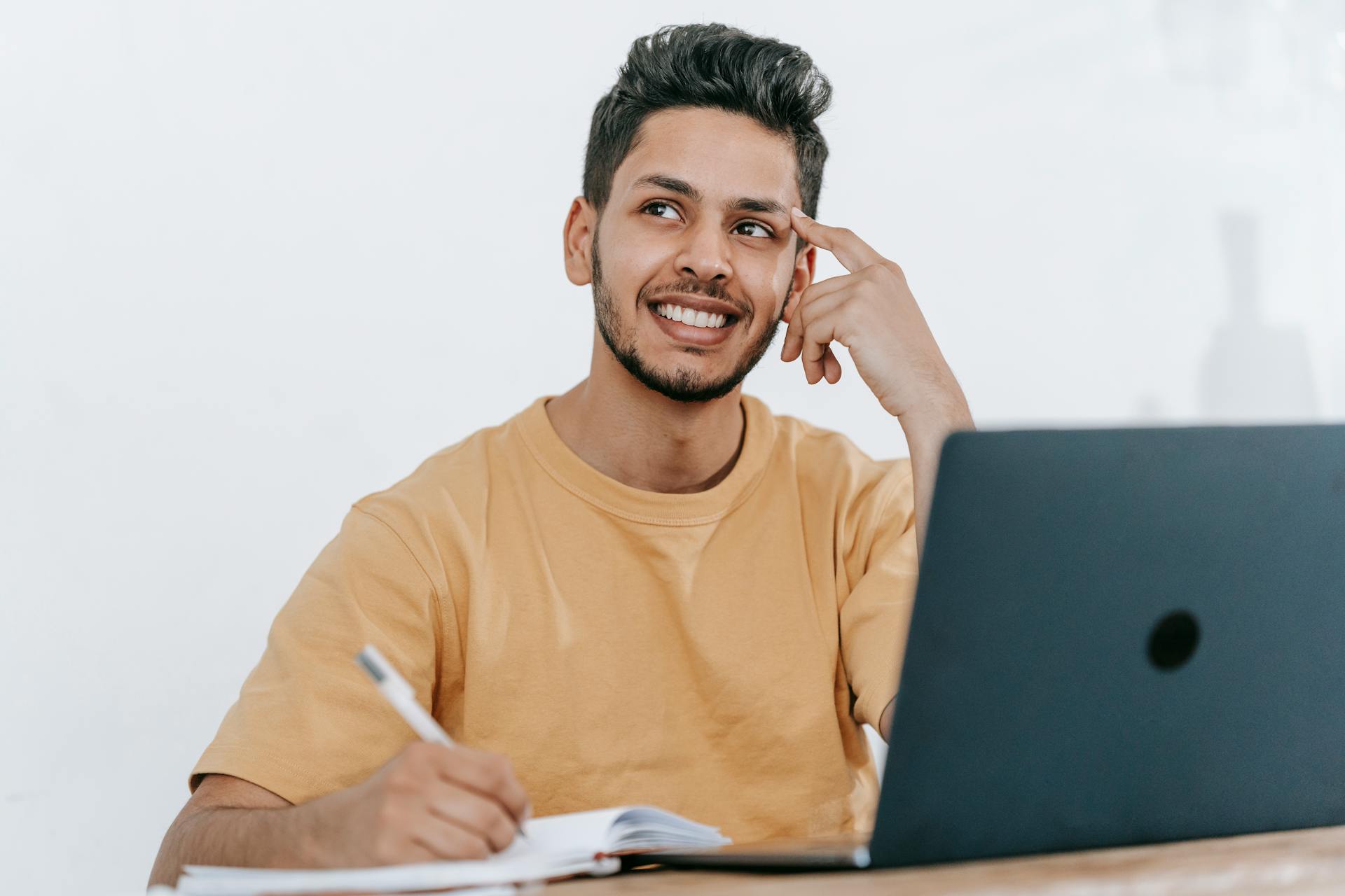 Young man thinking while on laptop