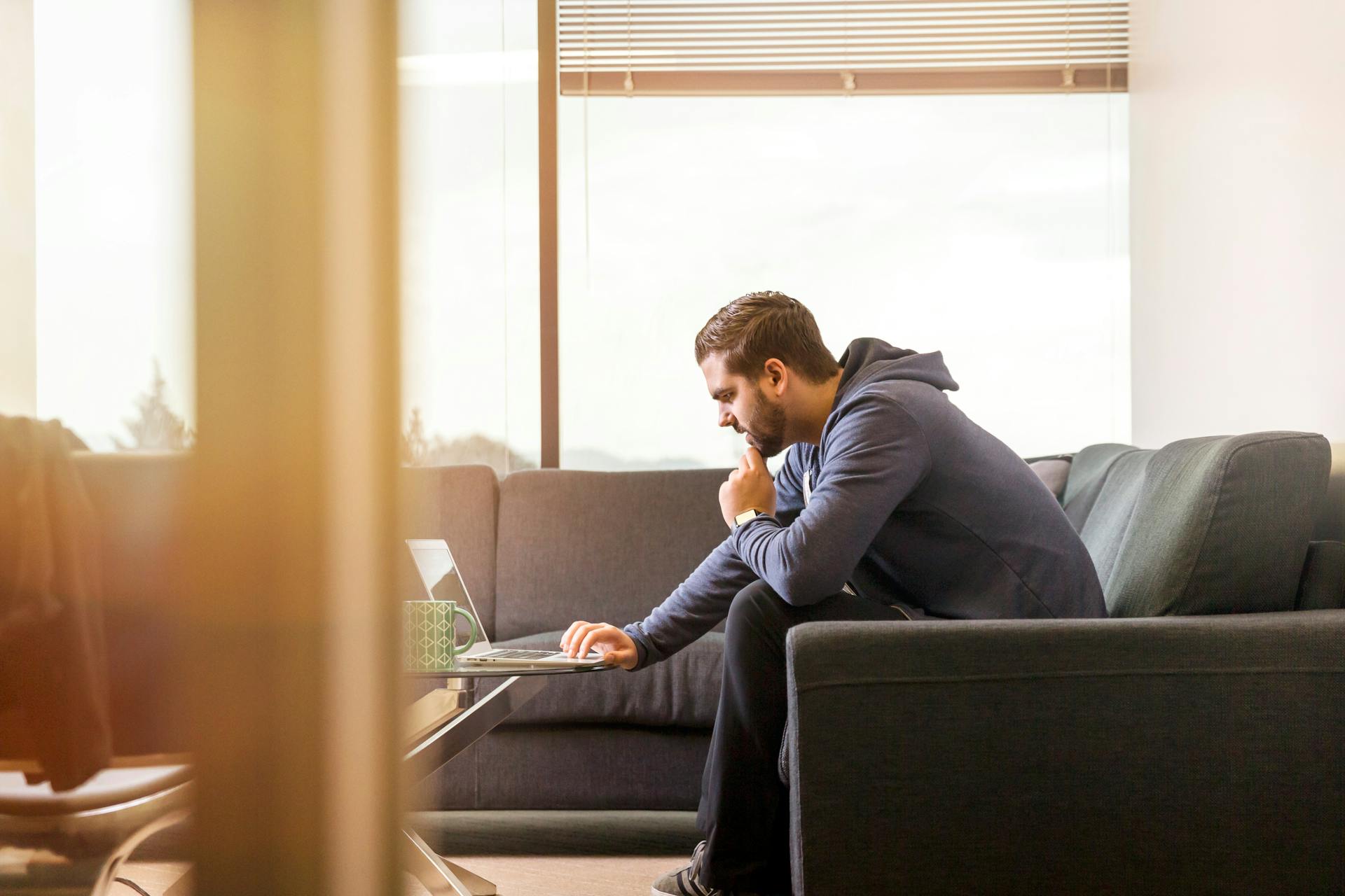 Man using a laptop while sitting on a couch