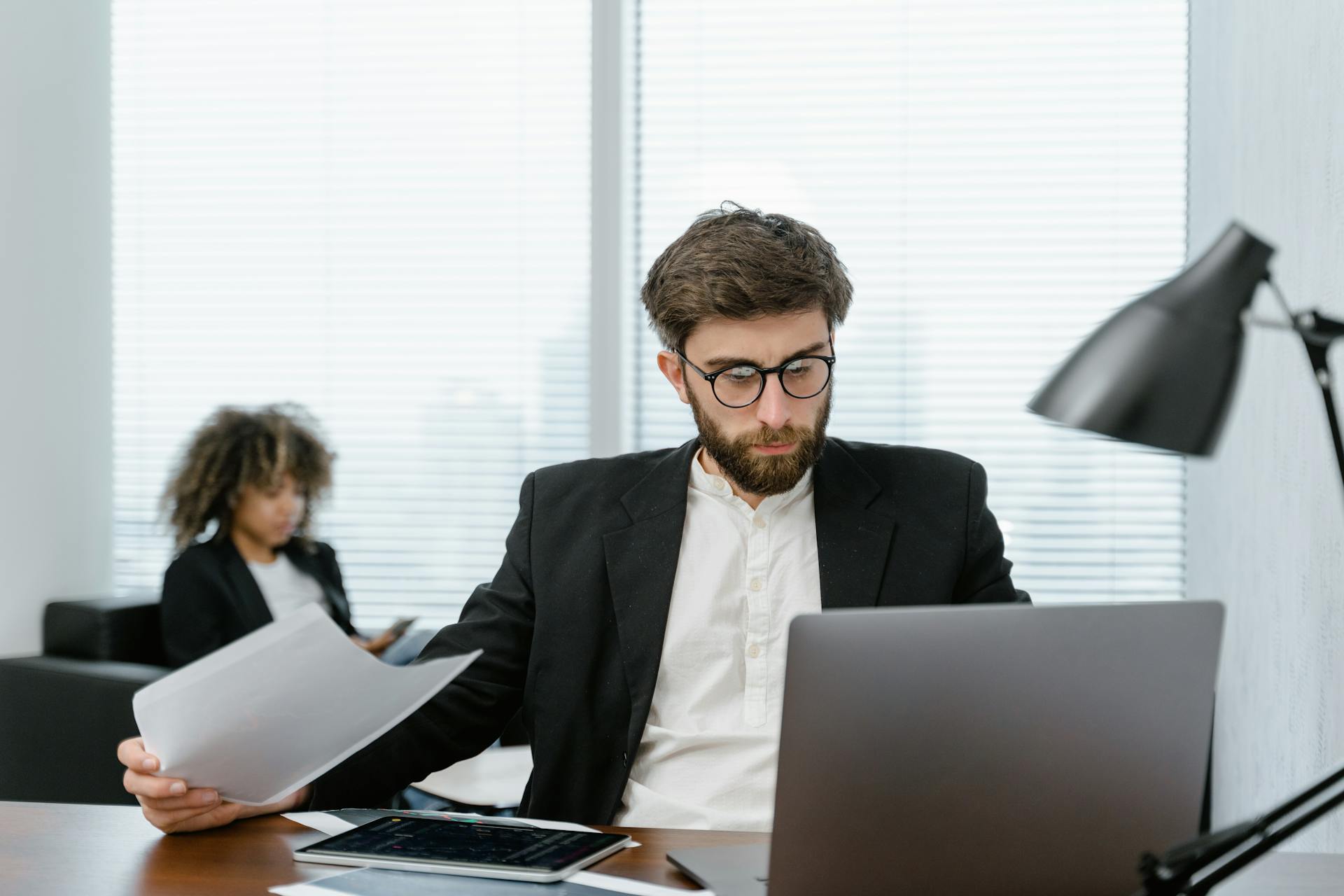 A man in a blazer with a laptop