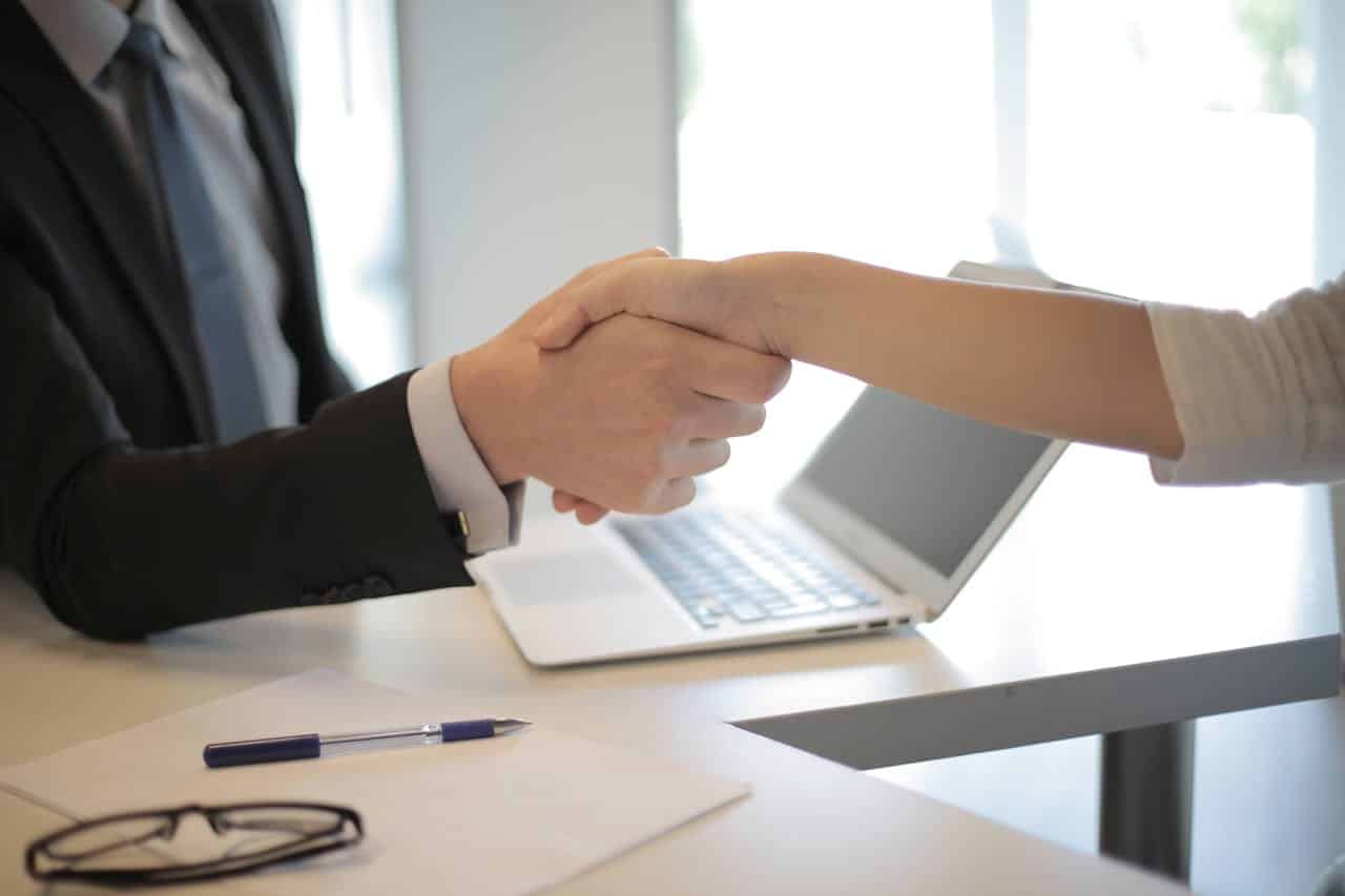 Alt text: person shaking hands with another person