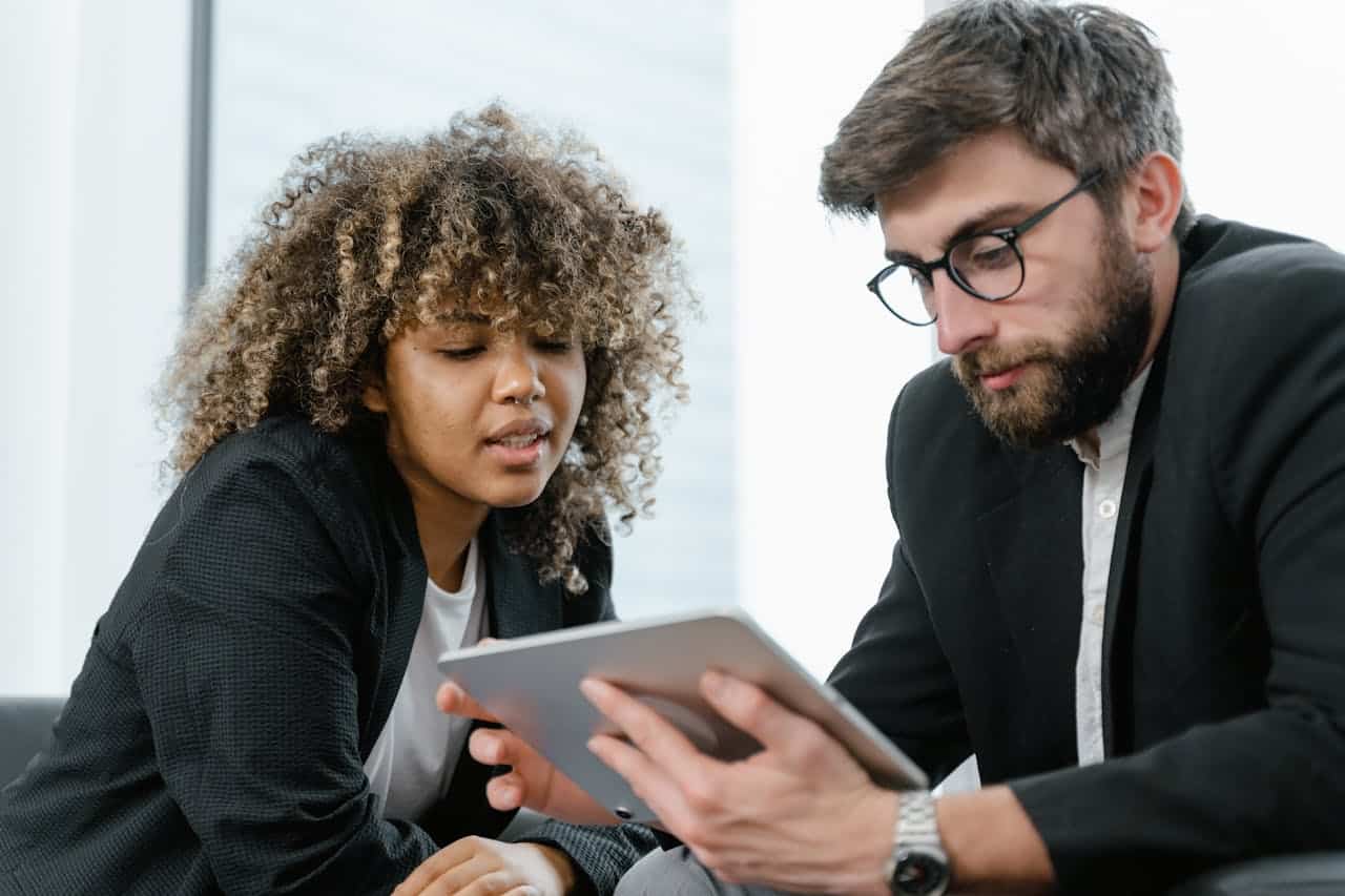 Man holding a tablet talking to a woman