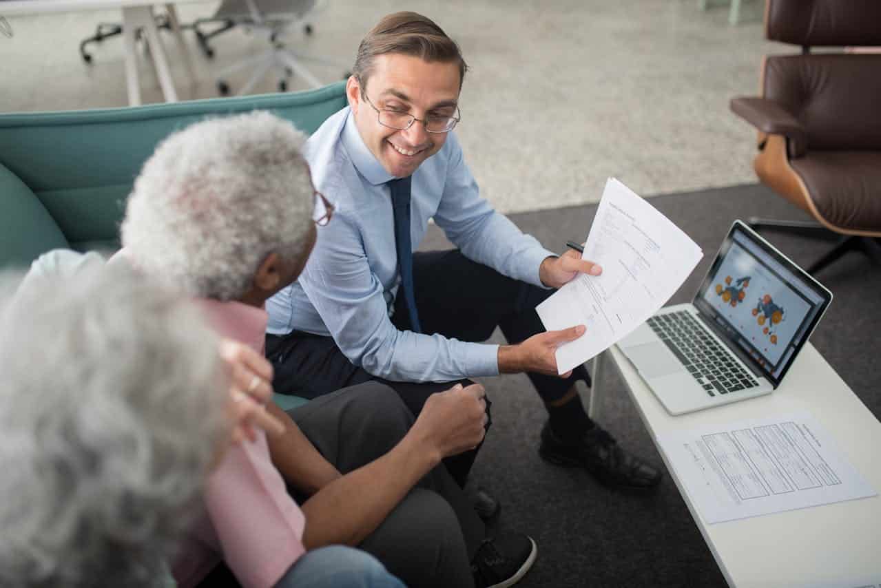 Young professional showing the elderly a sample of the Articles of Organization