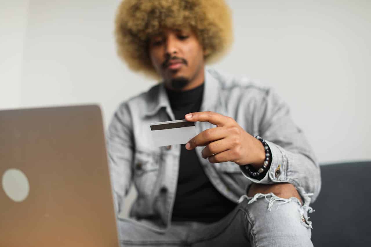 Man with afro holding a credit card