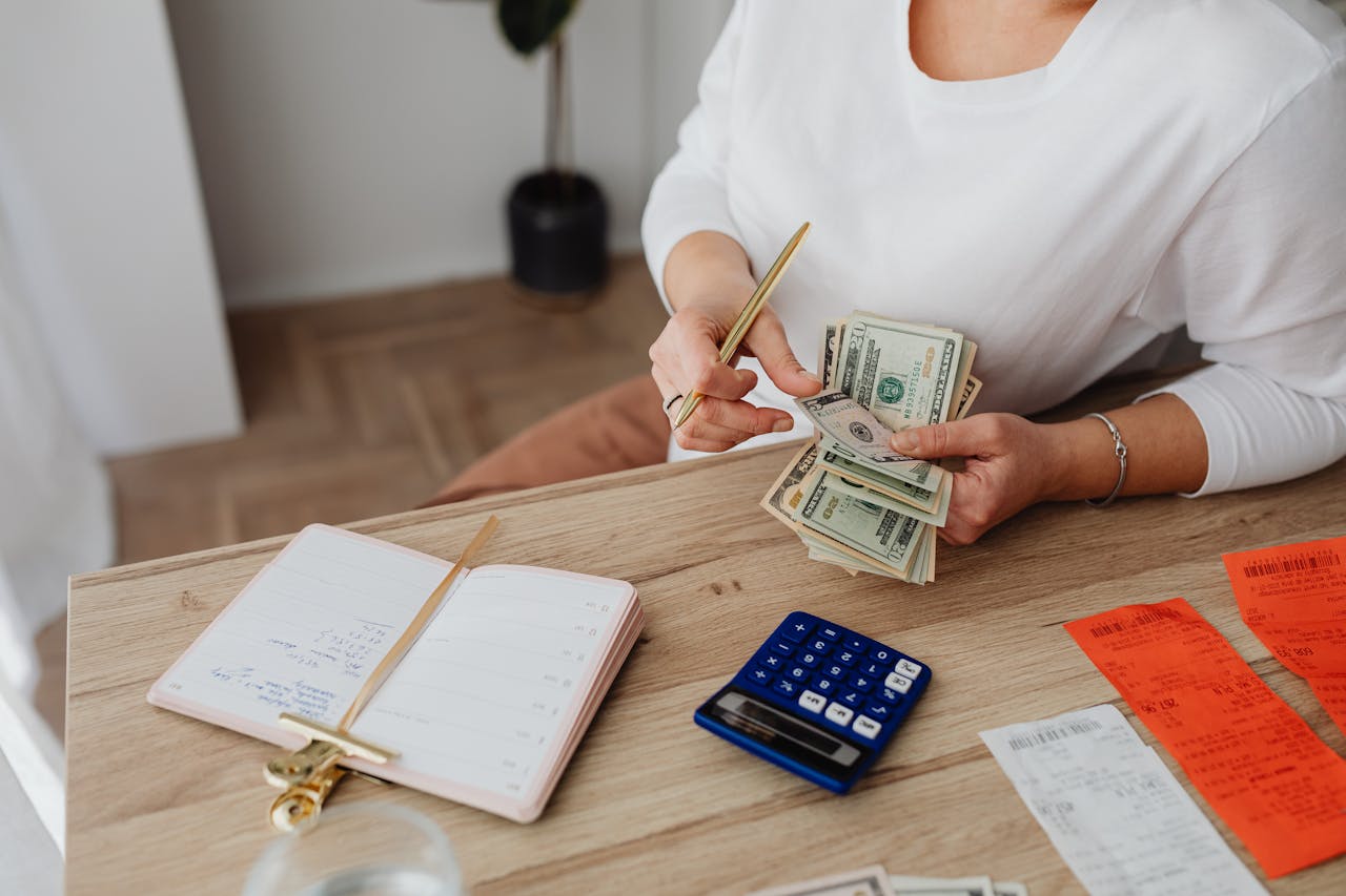 Woman writing on paper with calculator