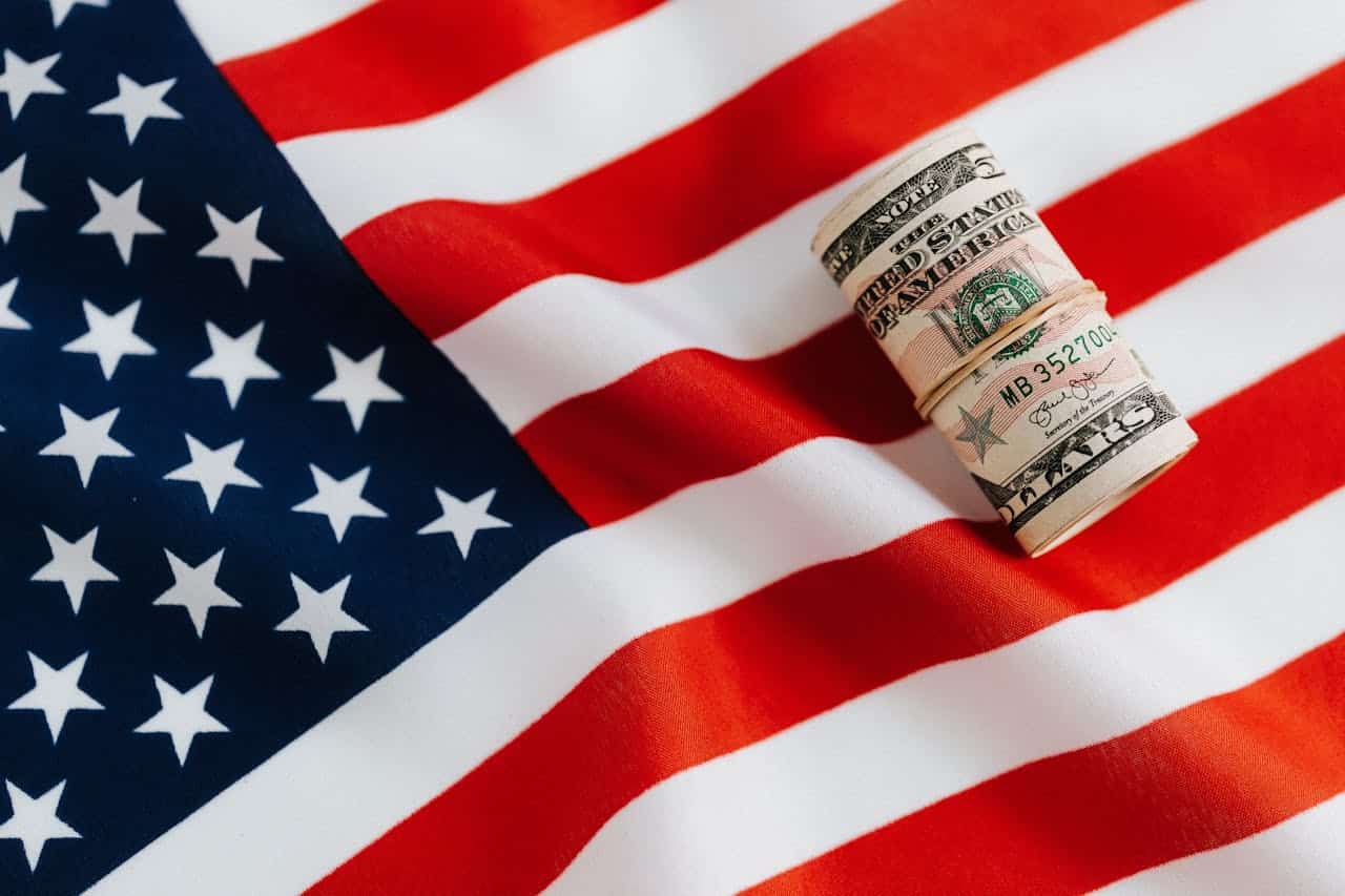 Rolled dollar bills on an American flag
