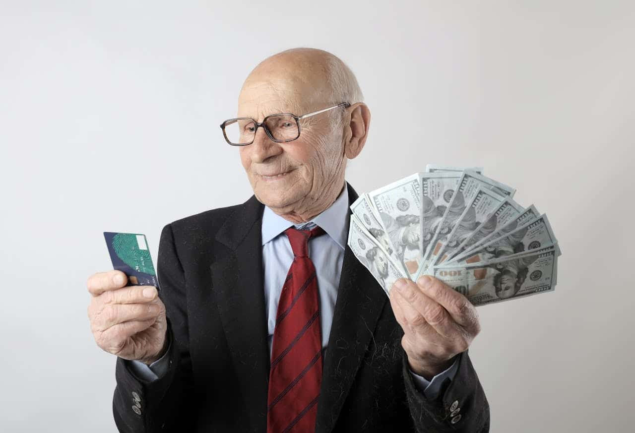An old businessman with a credit card and cash