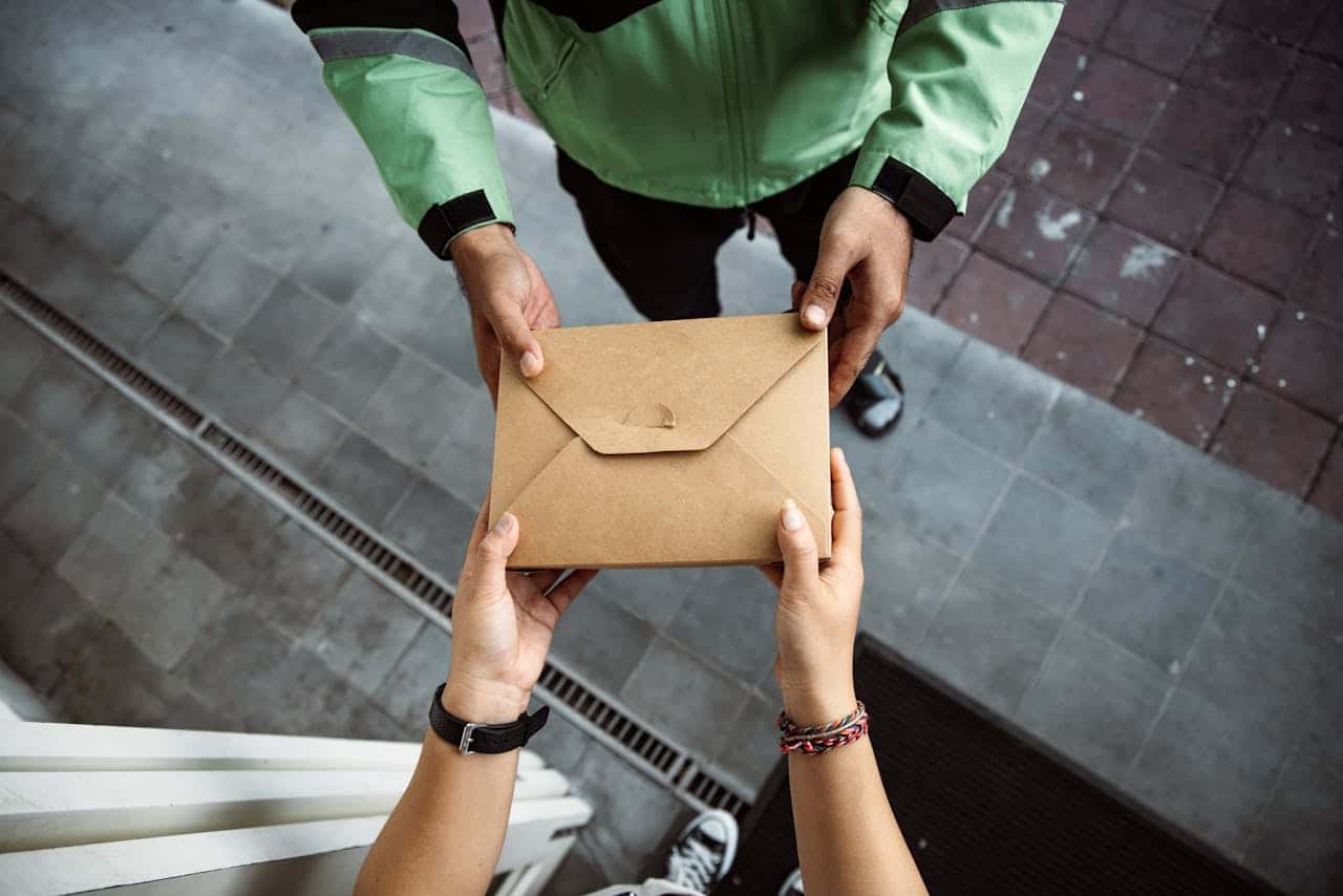 Two people holding an envelope with their hands