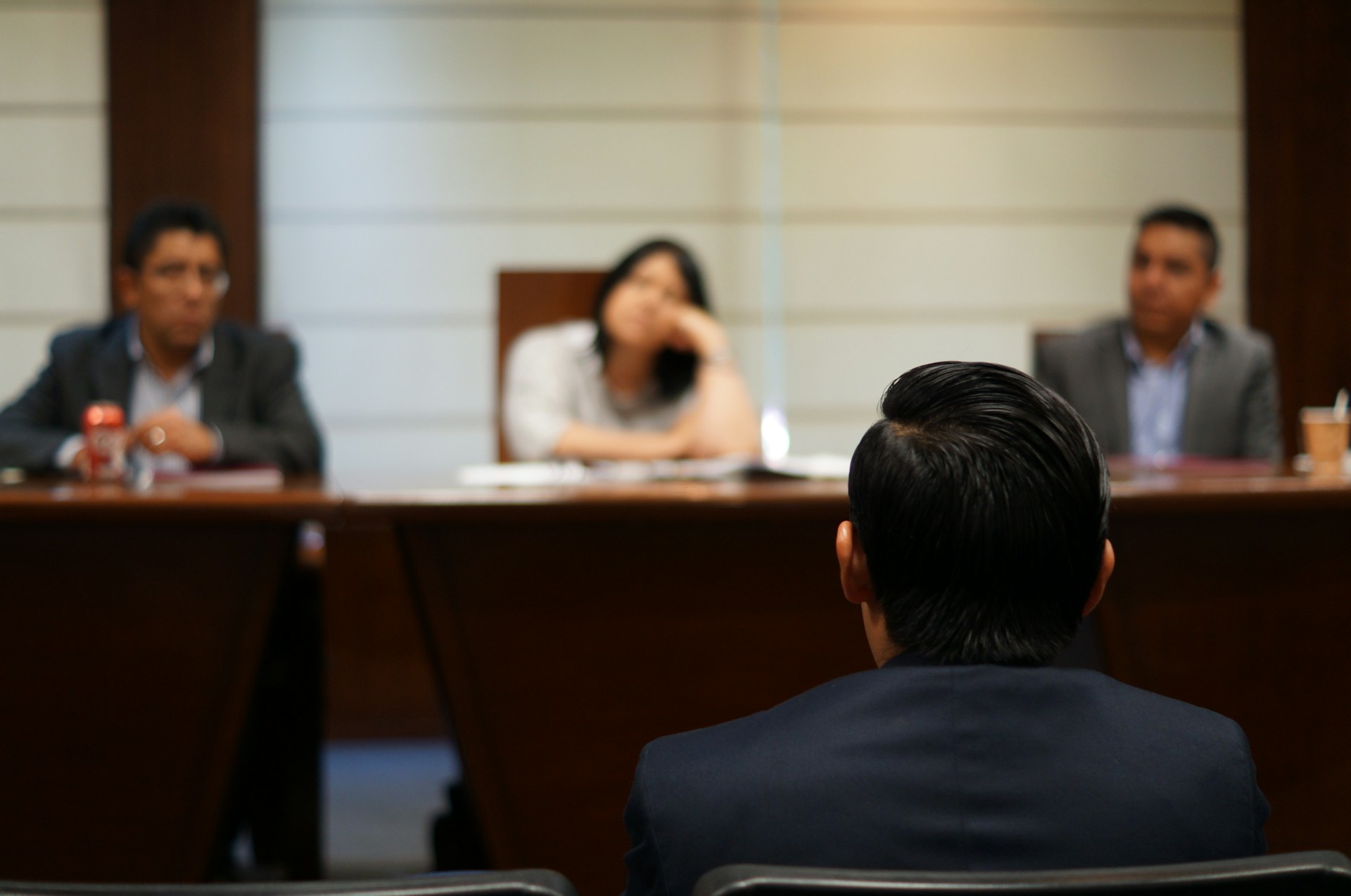 A man facing a panel in a courtroom