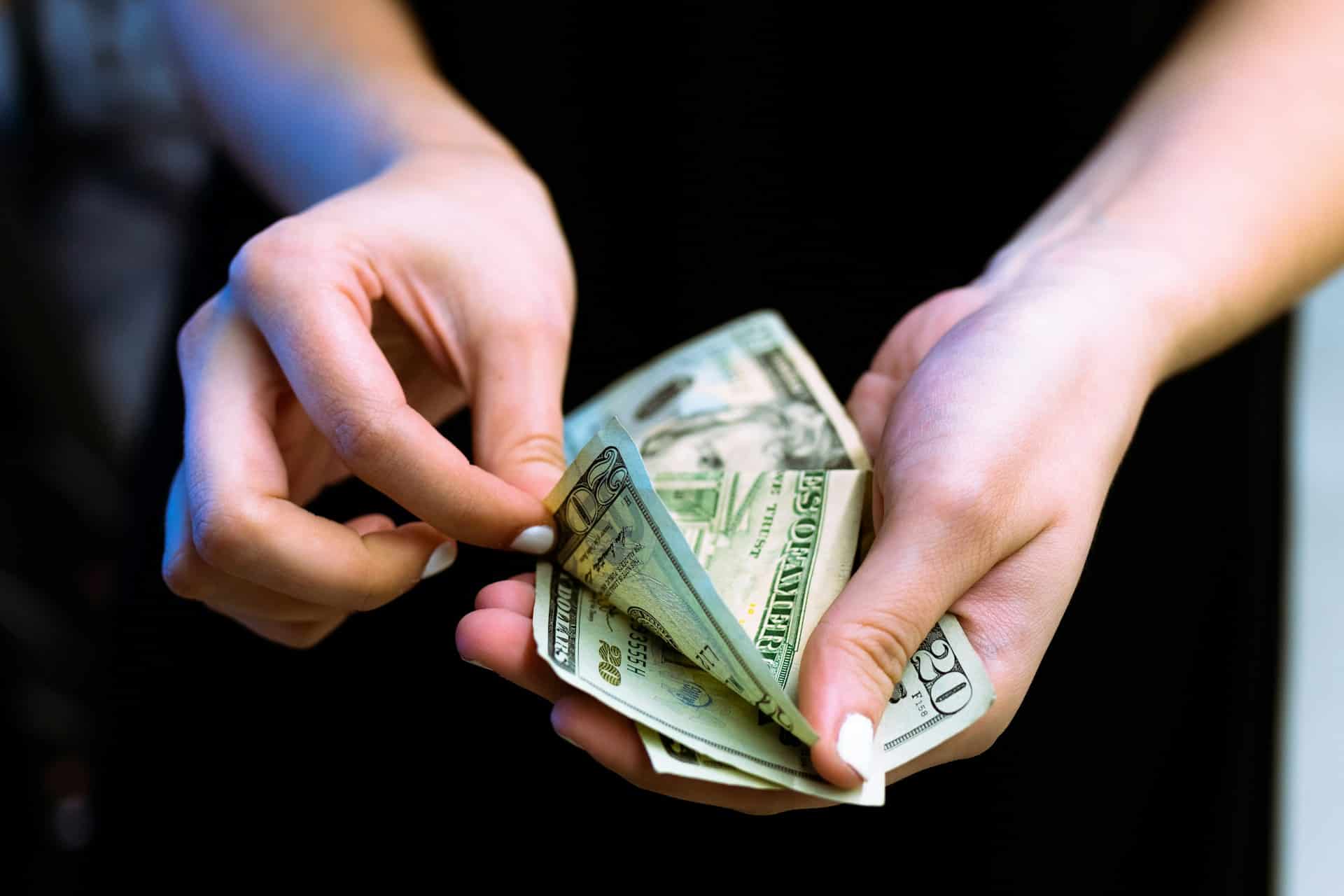 A close-up of a person holding dollar bills