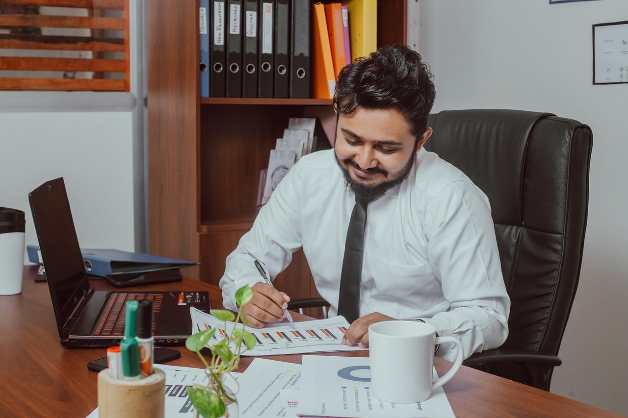 A male accountant reviewing papers with charts on them