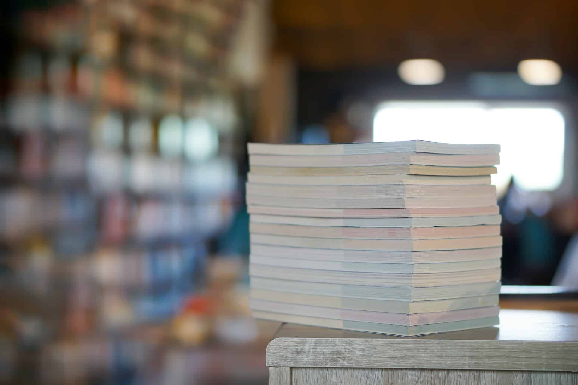 A stack of papers placed on top of a wooden table