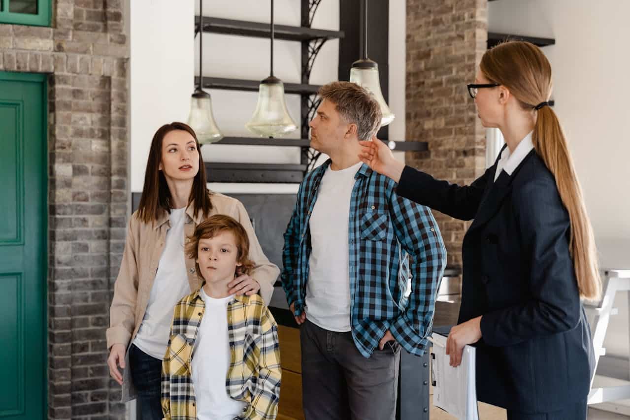 A female real estate agent showing an area of a house to a family