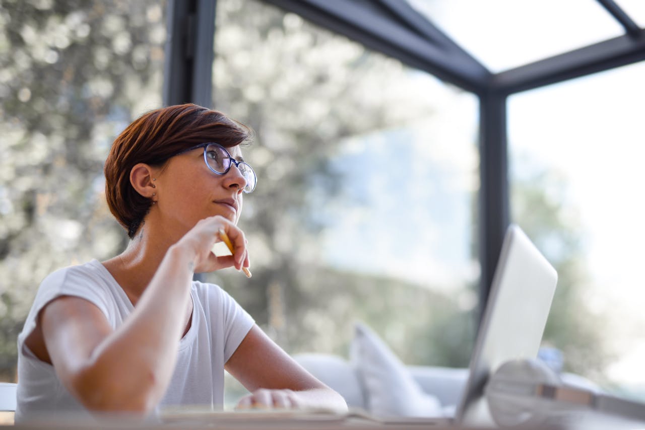 A woman thinking in front of her computer