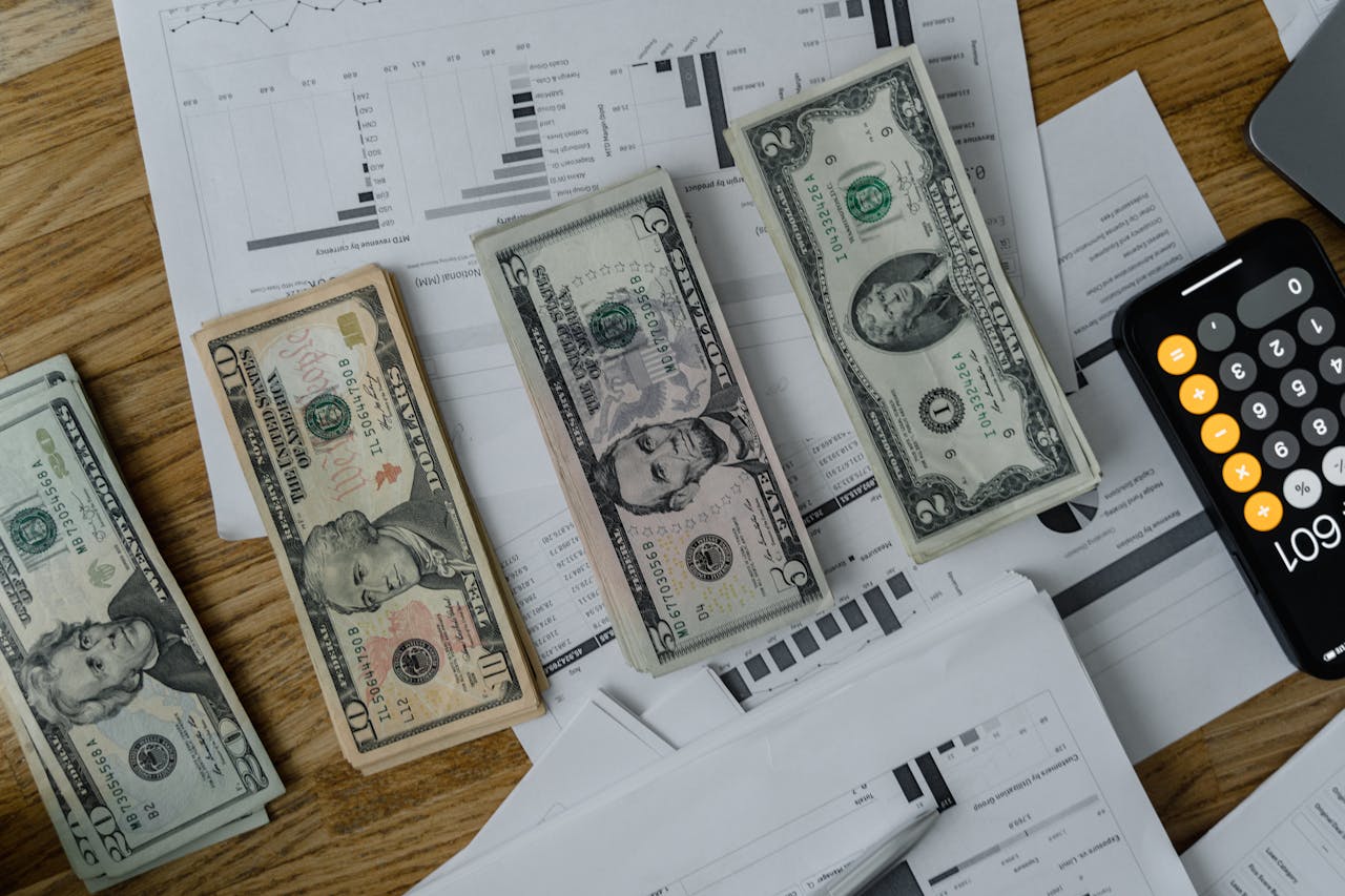 Piles of dollar bills and a calculator