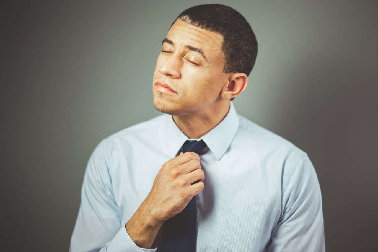 Tired businessman fixing his necktie
