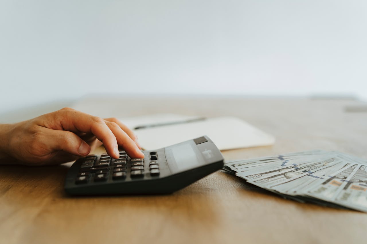 A person typing on a calculator