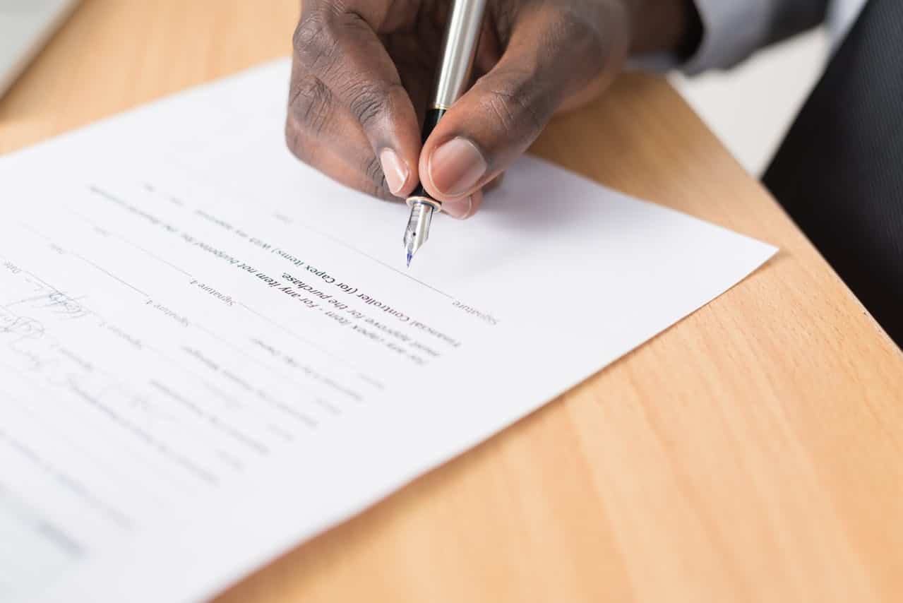 A man signing a contract with a fountain pen