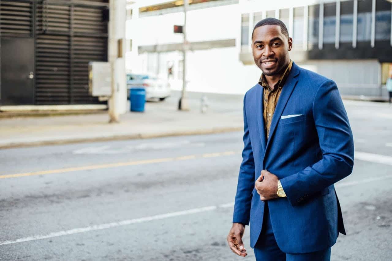 A man in a blue blazer posing on the street