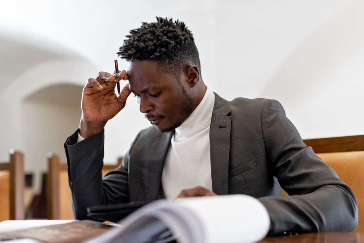 Businessman thinking while holding a pen
