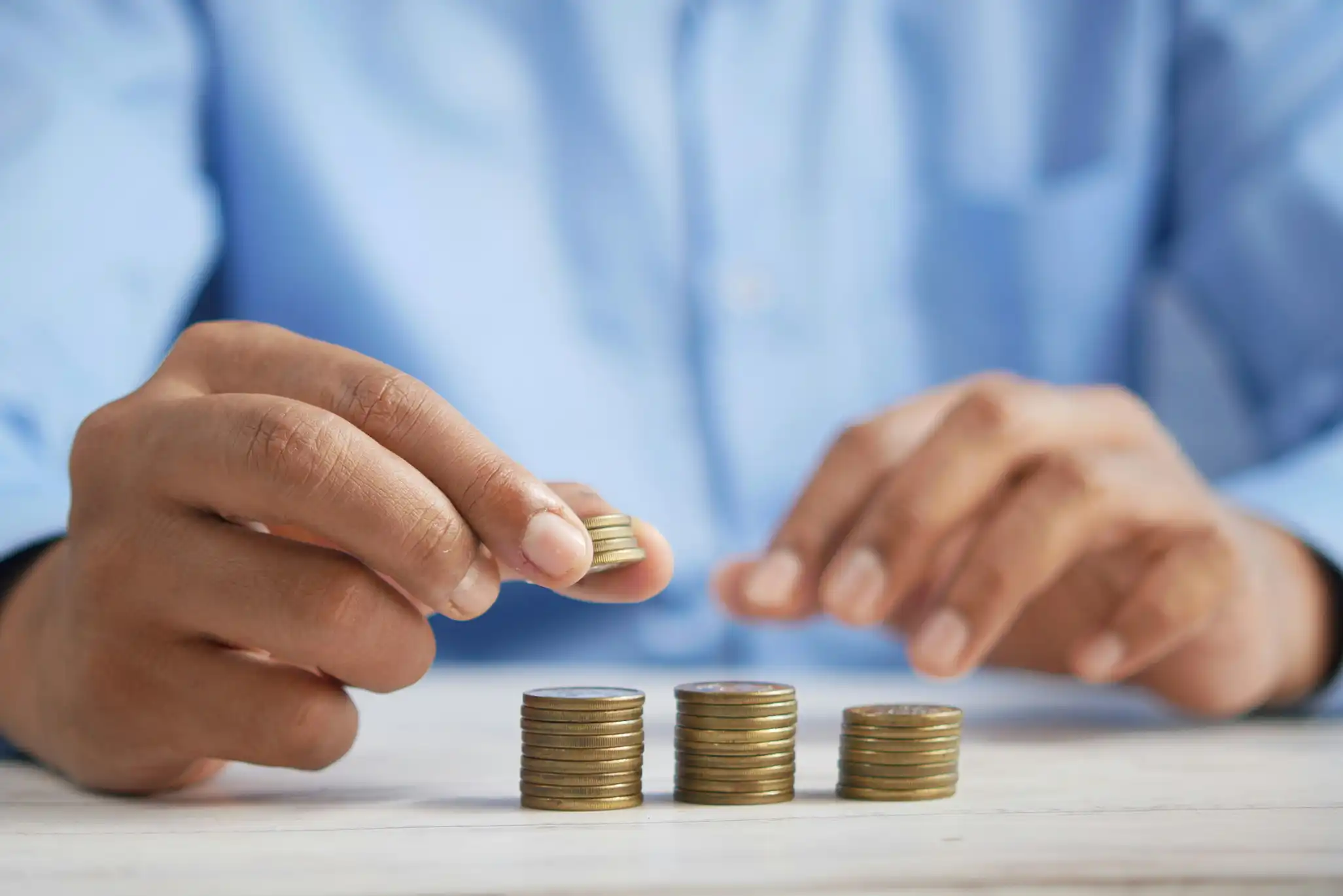 A man stacking coins on a table